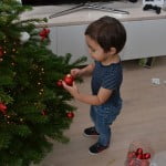 kind samen gezin kerstboom optuigen versieren